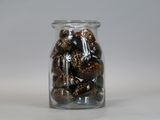 a glass jar filled with nuts on a white surface
