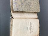 Deux vieux livres sont empilés l'un sur l'autre contre un mur