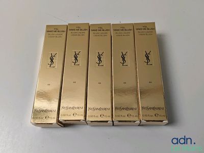 quatre boîtes de produits de beauté YSL posées sur une table blanche