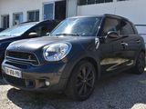 a black mini cooper parked in front of a white building