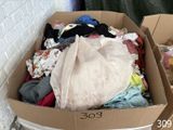 une boîte en carton remplie de vêtements et un sac en plastique