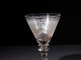 a close up of a wine glass on a table with a black background