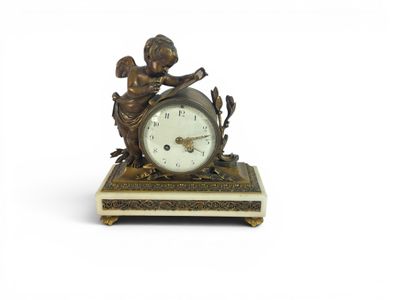 a small clock with a statue of a boy on it