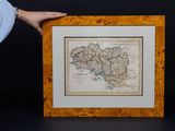quelqu'un tient une image représentant une carte devant un fond noir