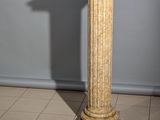 un socle en marbre surmonté d'une horloge, placé au milieu d'une pièce