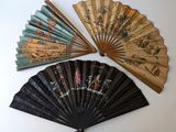 Plusieurs éventails asiatiques sont disposés sur une surface blanche