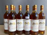 six bottles of wine are lined up on a table