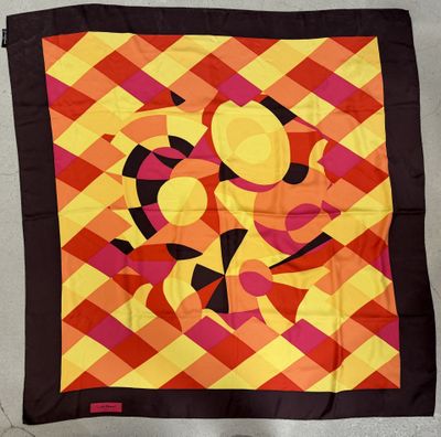 une image représentant un foulard carré orné d'un motif de couleurs orange et jaune sur fond noir