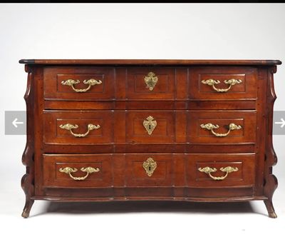 une commode ancienne avec des poignées et des boutons en laiton
