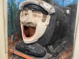 a wooden sculpture of a train engine with a laughing face