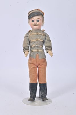 a small doll that is standing on a white surface