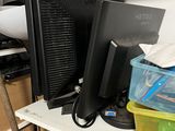 two computer monitors sitting on a shelf in a room
