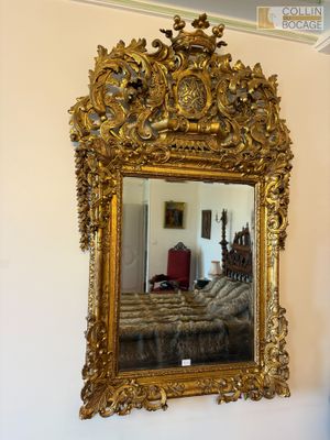 Important miroir en bois doré, sculpté de rinceaux feuillagé…