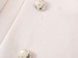 a close up of two buttons on a white jacket