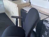 une chaise de bureau noire assise devant un bureau d'ordinateur