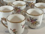 several cups and saucers are lined up on a table