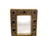 a close up of a gold frame with a mirror in it