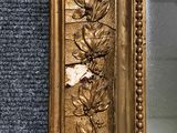 a gold frame with flowers and leaves on it