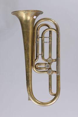 On voit un vieux tuba en laiton sur fond blanc.
