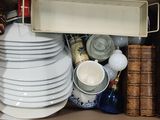 une boîte remplie d'assiettes et de bols, ainsi qu'un plateau de livres