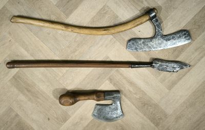 three different types of axes on a wooden floor