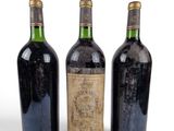 three bottles of wine sitting next to each other on a white surface