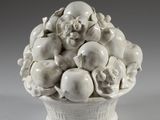 un vase blanc contenant un bouquet de fruits