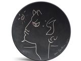 a black plate with a drawing of a woman on it
