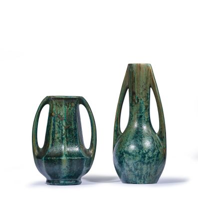 two green vases sitting next to each other on a white surface