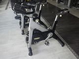 Plusieurs vélos d'appartement sont alignés en rang dans une salle de sport