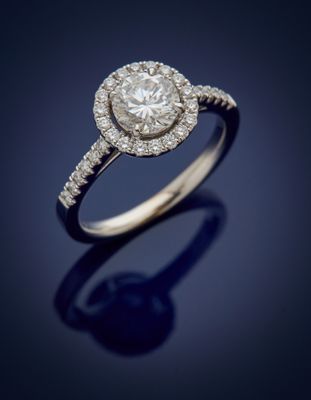 a diamond and white gold ring with a halo setting