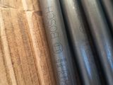 several steel pipes are stacked on top of each other on a wooden surface