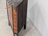 a small wooden cabinet with a marble top on the floor