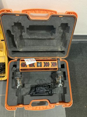 une mallette orange posée par terre, contenant des outils