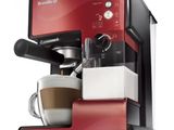 un gros plan sur une machine à café rouge avec une tasse de café