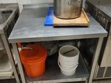 a kitchen with a stove, sink, and a pot on the counter