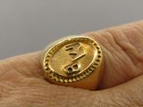 someone is holding a gold ring with a dollar sign on it