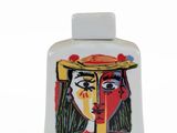 a picture of a bottle of perfume with a woman ' s face painted on it
