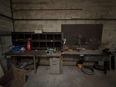 une photo d'un établi dans un garage, avec de nombreux outils