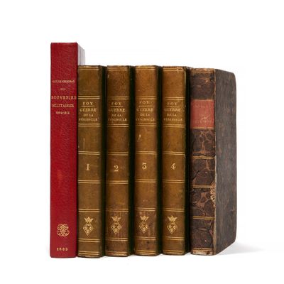 plusieurs vieux livres sont alignés sur une surface blanche