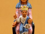 figurine représentant une femme et un enfant assis sur une chaise