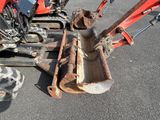 a close up of a tractor and a small excavator in a parking lot