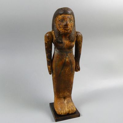 an old wooden statue of a woman holding a bird in her hand