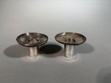 pair of silver plated candlestick holders on a white surface