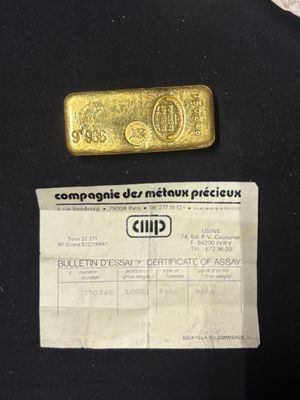 a gold bar and a piece of paper on a table