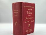 a red book sitting on top of a table next to a white table