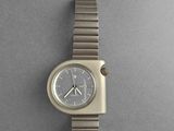 an image of a silver watch on a gray surface with a gray background