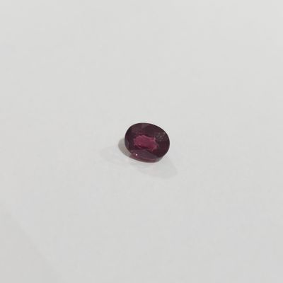 un rubis rouge de forme ovale sur un fond blanc