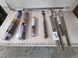 many different types of drill bits on a shelf
