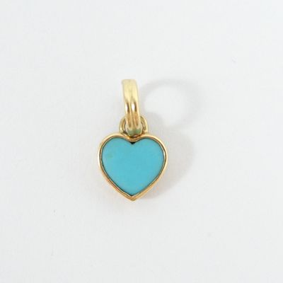 a close up of a blue heart shaped pendant on a white surface